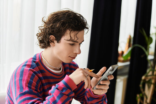 Curly-haired non binary student engaged with phone in modern, vibrant apartment