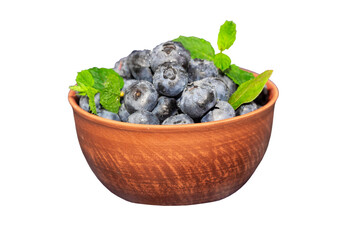 Blueberries in a ceramic bowl isolated on white background. Dark blue, ripe, raw berries with mint leaves