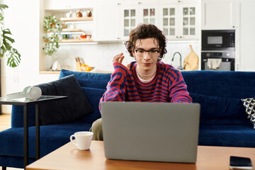 Curly-haired non binary student engaging in creative online learning at home
