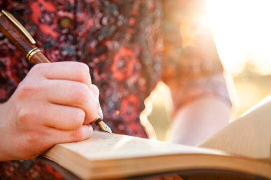Writer holding fountain pen and notebook for writing in