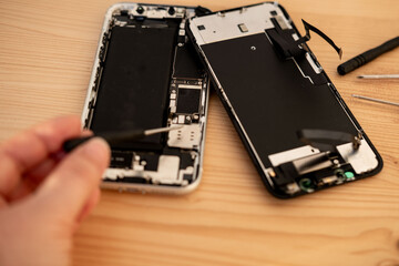 Hands repairing smartphone hardware with small tools. Mobile phone maintenance, repair service and technology concept, technical support, service center, display replacement