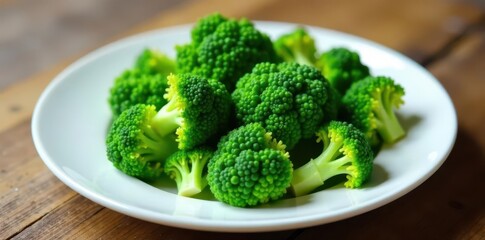 Crisp broccoli crowns arranged neatly on a clean white plate atop aged wood , wood, table, clean eating