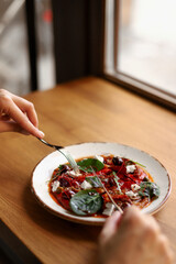 Marinated peppers with feta cheese, olives, capers and basil on a white plate