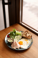 Breakfast, plate with scrambled eggs, toast, chicken breast, cheese, tomatoes, lettuce and sauce