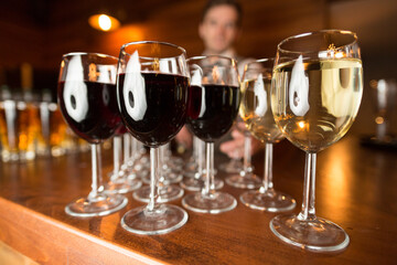 A beautiful row of elegant wine glasses is lined up perfectly on a bar
