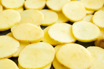  raw potato slices in a tray ready to be baked close-up