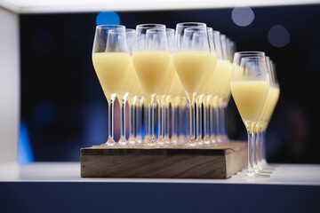 A beautiful row of wine glasses elegantly filled with yellow liquid