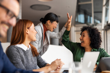 Team Celebrates Success with Enthusiastic High Five in Office