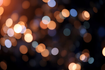 Warm orange and cool blue bokeh circles softly glow against a dark backdrop, creating a magical and dreamy atmosphere of light and color.