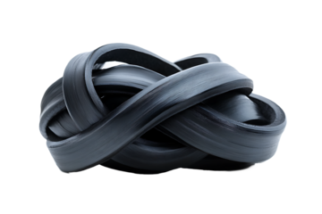A tangled mass of dark rubber strips intertwined against a stark black background in a studio shot