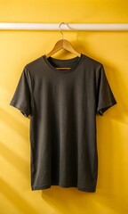 Studio shot of a plain black t-shirt hanging on the wall, ready for custom designs, branding, and personalization in minimalist fashion.

