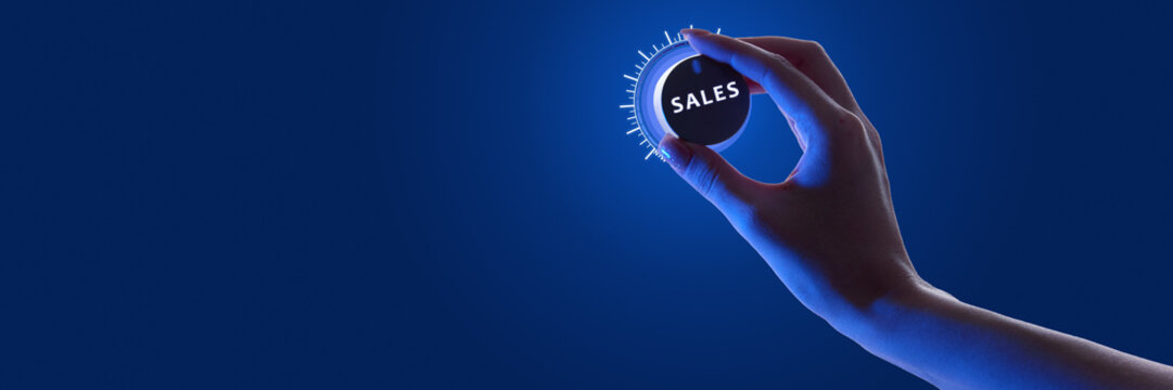 Person adjusting glowing dial labeled SALES against dark background in neon, optimization of sales performance. Concept of business, control of sales, revenue, marketing, growth. Banner