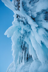 A stunning closeup image of a frozen waterfall against a bright blue sky