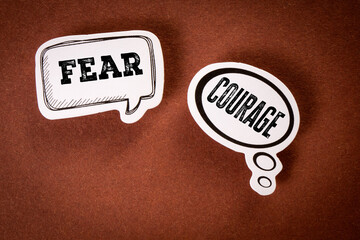Fear vs Courage Concept with Thought Bubbles on Brown Background