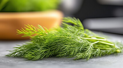 Fresh dill herb on a stone countertop with a wooden bowl in the background, perfect for enhancing culinary dishes and flavor profiles