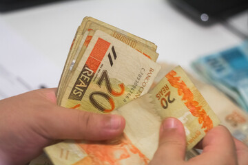 Businessman counting and exchanging money - Brazilian Real - Reais.