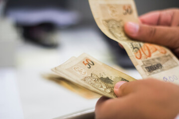 Businessman counting and exchanging money - Brazilian Real - Reais.
