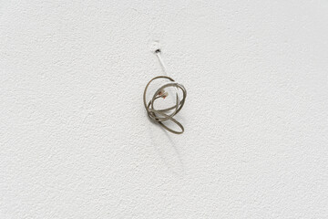 Electrical wires protruding from a sidewall facing the street, prepared for connecting a light...