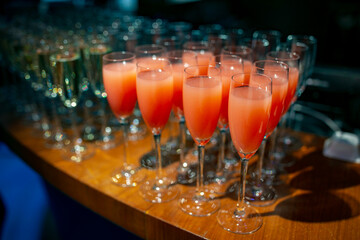 Row of champagne glasses with pink liquid on a wooden table
