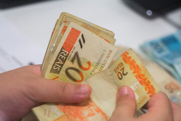 Businessman counting and exchanging money - Brazilian Real - Reais.