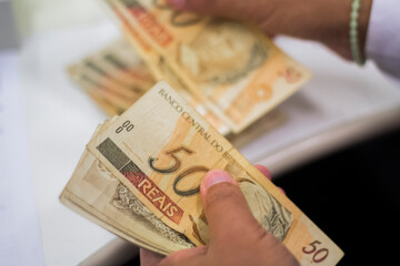 Businessman counting and exchanging money - Brazilian Real - Reais.