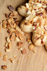 Deliciously crafted pastry with crushed nuts spread across a wooden board