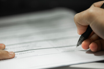Crop shot of a business person with pen signing document