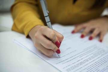 Crop shot of a business person with pen signing document