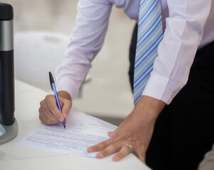 Crop shot of a business person with pen signing document