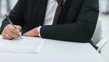 Crop shot of a business person with pen signing document