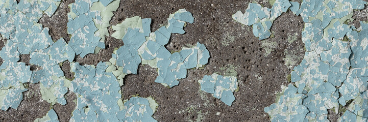 Peeling paint on the wall. Panorama of a concrete wall with old cracked flaking paint. Weathered...