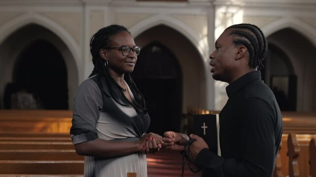 Priest holding bible listening to woman talking in church in slow motion