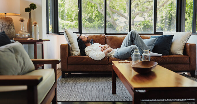 Home, relax and man on sofa, sleeping and resting with weekend break in living room. Apartment, happy person and guy on couch, comfortable and chilling with peace, calm and easy with afternoon nap