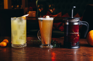 Three different beautiful cocktails in warm colors on a flower background