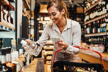 Beautiful young and elegant woman buying some healthy food and drink in modern supermarket or grocery store. Lifestyle and consumerism concept.