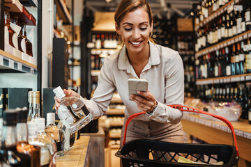 Beautiful young and elegant woman buying some healthy food and drink in modern supermarket or grocery store. Lifestyle and consumerism concept.