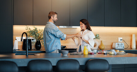 Mature couple, dancing and cooking in kitchen with love, bonding and celebration for anniversary in home. People, man and woman with holding hands, happy and playful rhythm with relationship at house