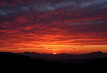 fiery red and orange sunset over silhouetted mountain range