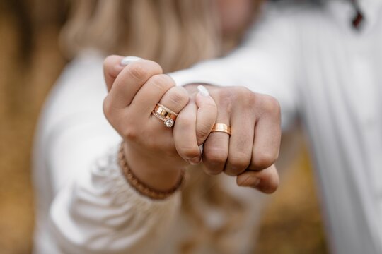 A guy puts a diamond engagement ring on his girlfriend's finger, close-up photo. An offer of a hand and a heart. Wedding ring - Powered by Adobe
