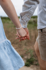 A man holds a woman's hands with wedding rings. Support for loved ones. Couple outdoor love