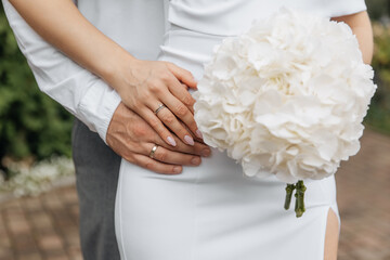A man holds a woman's hands with wedding rings. Support for loved ones. Couple outdoor love