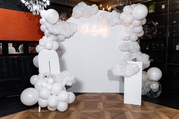 Luxurious arch photo zone for a gender reveal party in white in a restaurant. Oh baby
