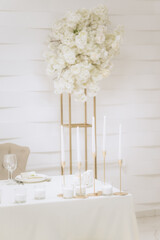 Wedding decoration in a restaurant. White flowers, serving and decor for a wedding