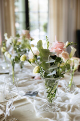 Decorated table with fresh flowers and serving with postcard. Celebrating a party in a restaurant