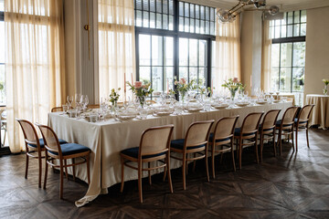 Decorated table with fresh flowers and serving with postcard. Celebrating a party in a restaurant