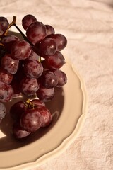 Plate with red Spanish seedless grapes of the Kyshmysh variety