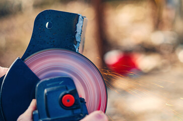 Obraz premium Hand using angle grinder to cut metal with sparks in construction site