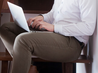 Naklejka premium Young casual entrepreneur working on laptop at home office.