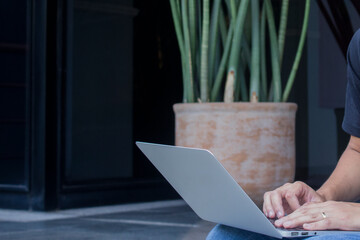 Young casual entrepreneur working on laptop at home office.