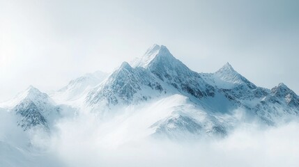 Obraz premium Snowy mountain peaks rise above misty clouds